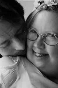 Esimerkkikuva tunteesta ja läheisyydestä – mustavalkoinen pariskunnan kasvokuva, ilon hetki. Kuvaajana Johanna Kare.